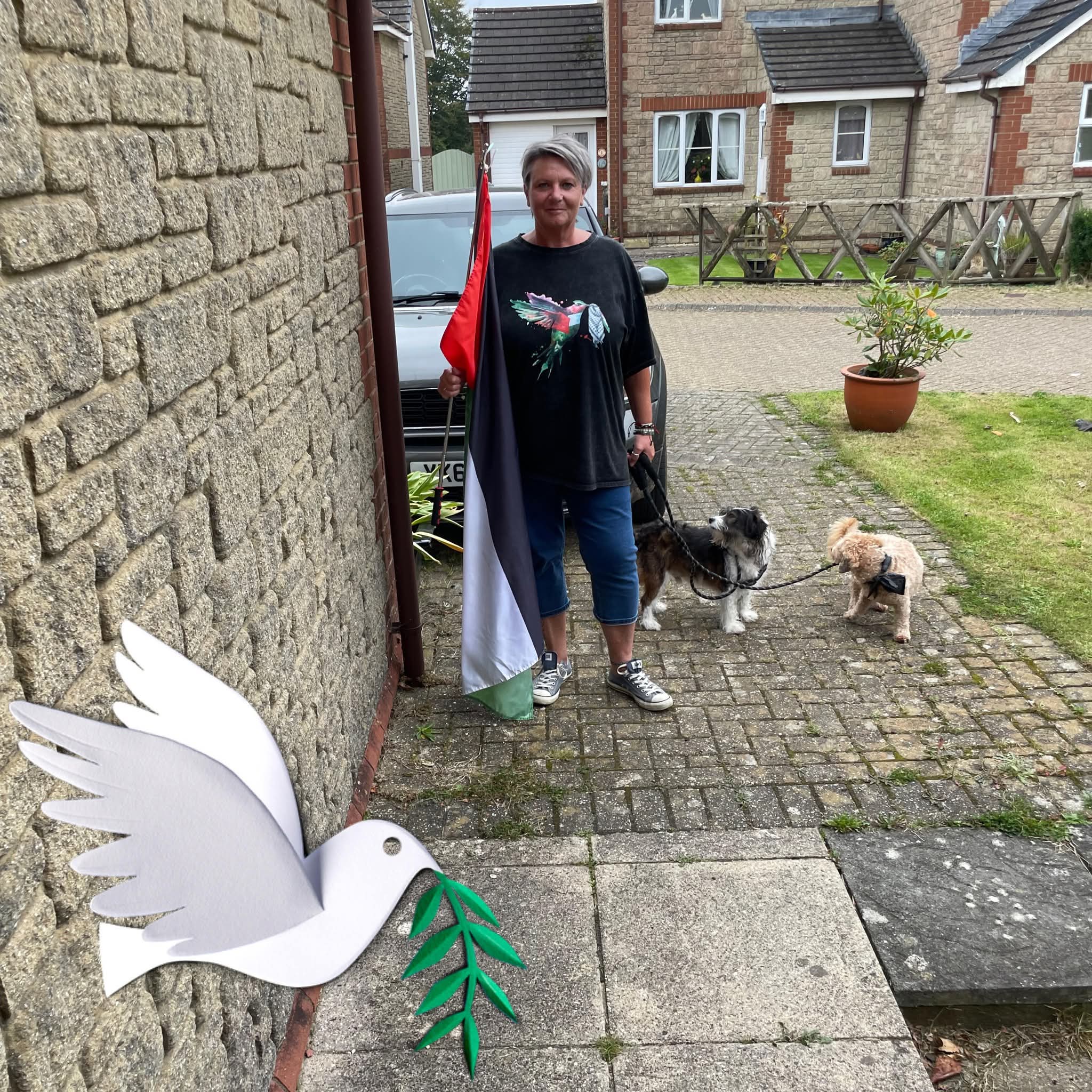 Sam with her dogs and peace dove artwork